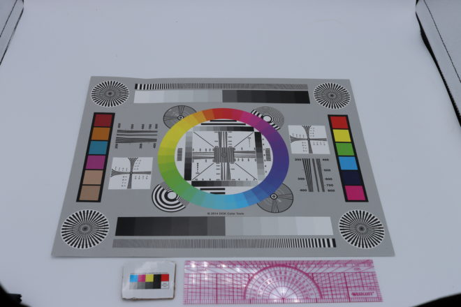 A calibration card in a lightbox next to a ruler and a colour swatch.